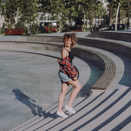 Photo of Woman in Black Tank Top Walking on Stairs at a Park