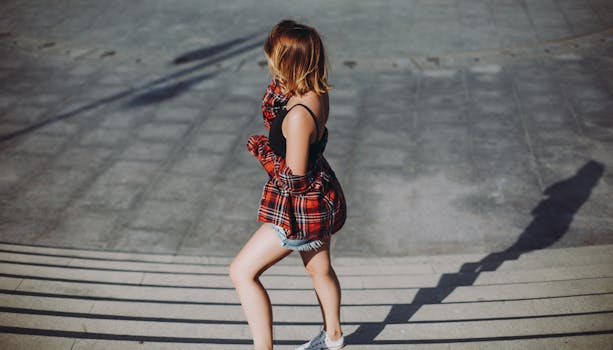 Young woman posing fashionably on sunlit steps in Baku, Azerbaijan.