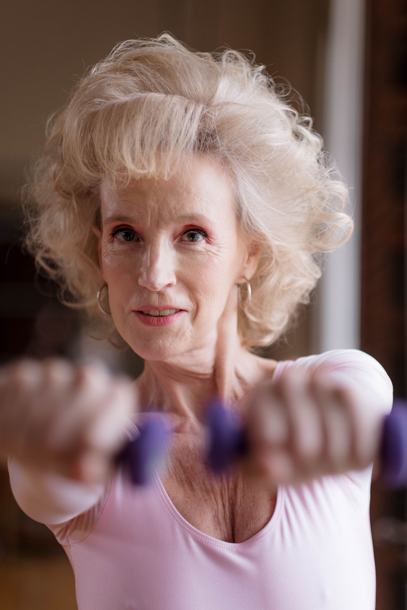Older woman holding dumbbells during a strength training session
