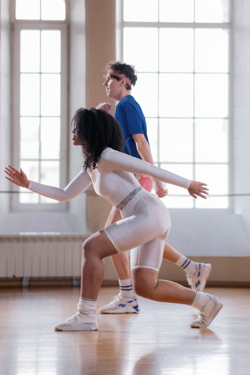 Man and Woman in Sports Wear Doing Lunges