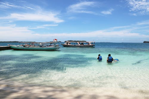 Free Boats and People on Shallow Water of the Beach Stock Photo
