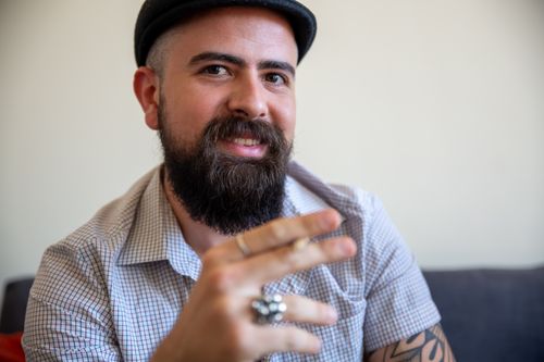 Free Portrait of a happy bearded man wearing a checkered shirt, smiling indoors. Stock Photo