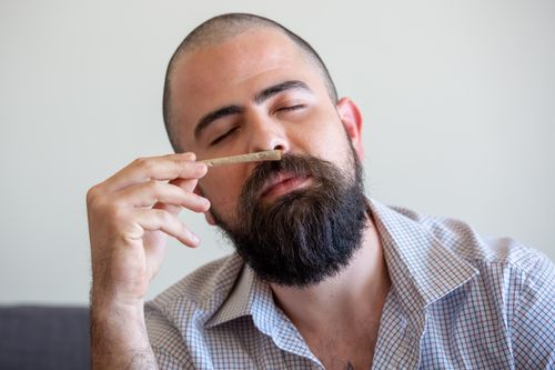 Free Close-up of a bearded man relaxing indoors with a joint, eyes closed, in Portugal. Stock Photo