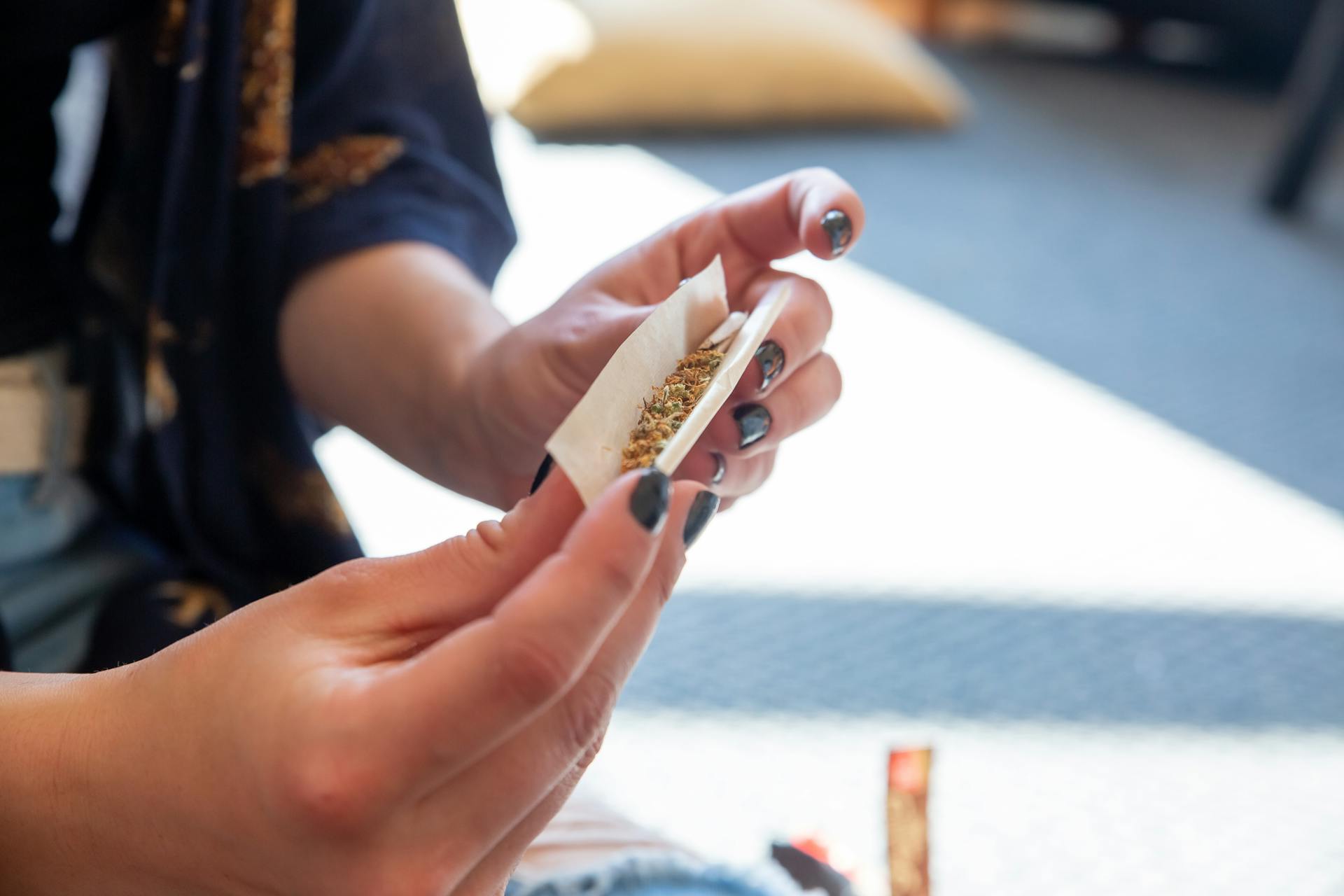 A Person Rolling Cannabis Into a Joint