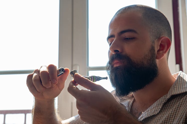 Man In Plaid Shirt Holding A Smoking Pipe