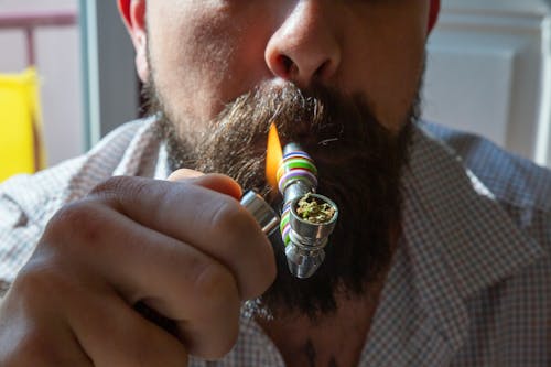 A Man Smoking Cannabis Using a Pipe