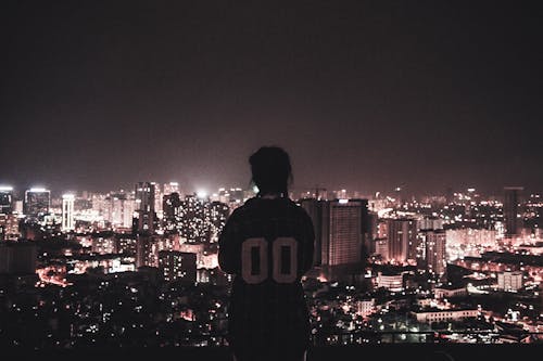 Free Photo of a Person Watching over City Lights during Night Time Stock Photo