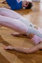 Woman in White Brassiere and White Pants Lying on Brown Wooden Floor