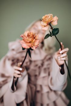 Elegant portrait of a woman holding two roses with a soft, artistic blur effect.