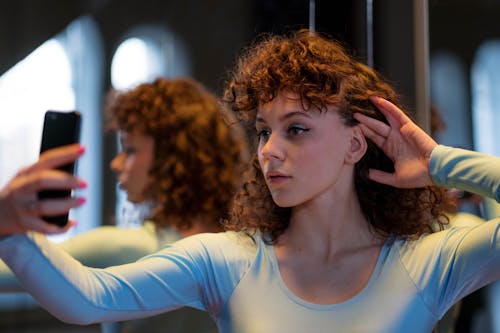 Close-Up Shot of a Curly-Haired Woman Taking Selfie Using a Mobile Phone