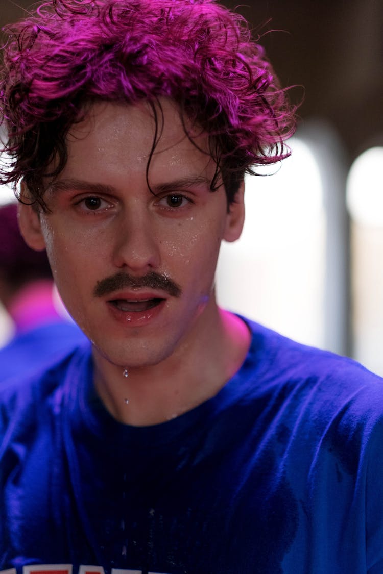 Close-Up Shot A Man In Blue Shirt Looking At Camera While Sweating