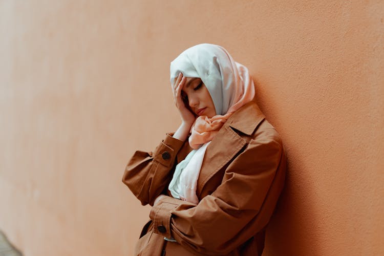 

A Woman Wearing A Hijab Holding Her Head