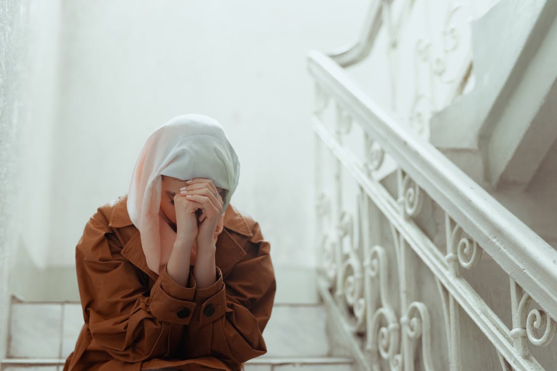 wanita dalam kesedihan dan membaca doa ketika sedih