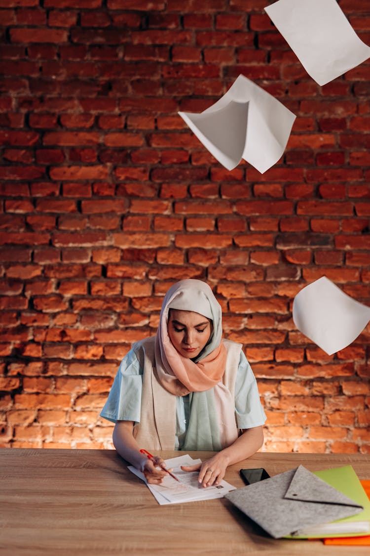 Woman Wearing Headscarf Writing On A Table