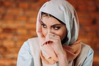 Woman in White Hijab Covering Her Face With White Textile