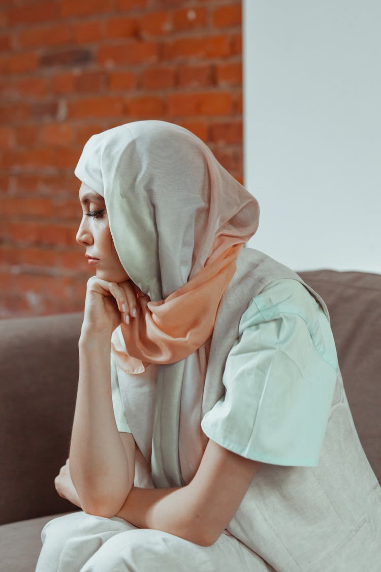 Woman Wearing Headscarf With Hand On Chin Sitting