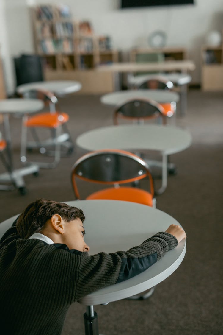 A Boy Leaning On A Table