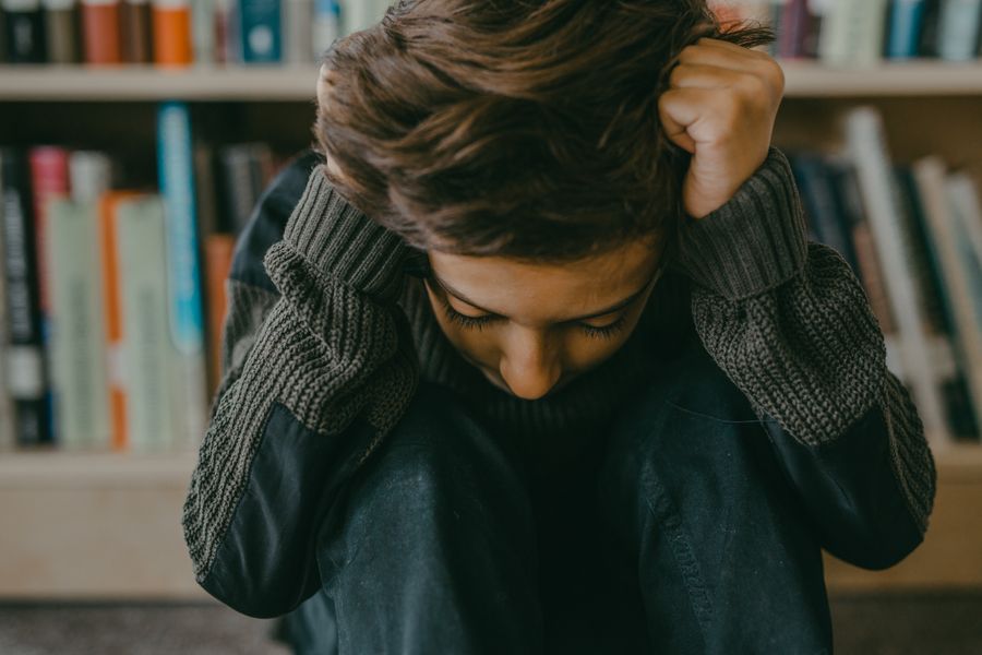 Distressed young person, head down