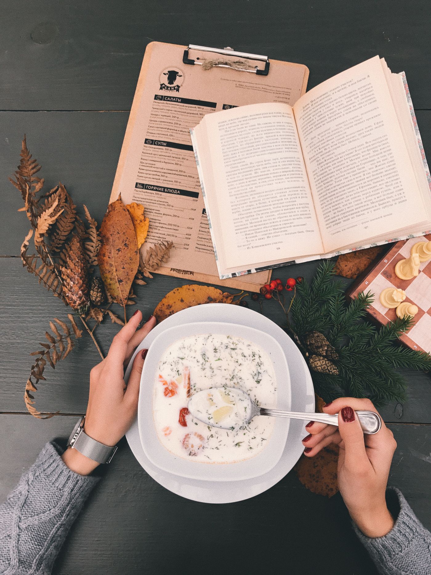 Un bol de soupe chaude posé sur une table en bois avec des feuilles d'automne, ambiance cosy