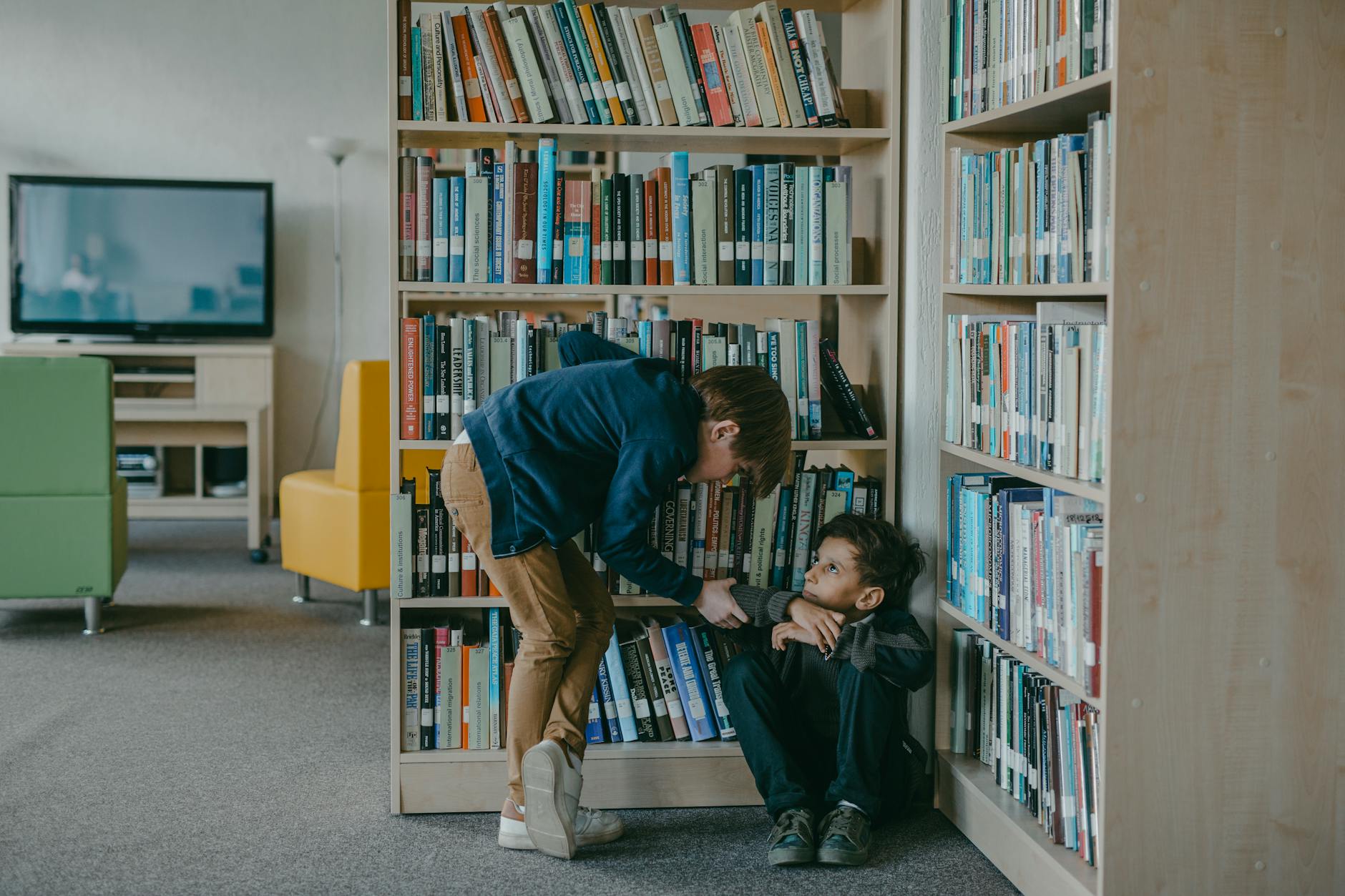 A child bullies another student in a school library, highlighting social issues.