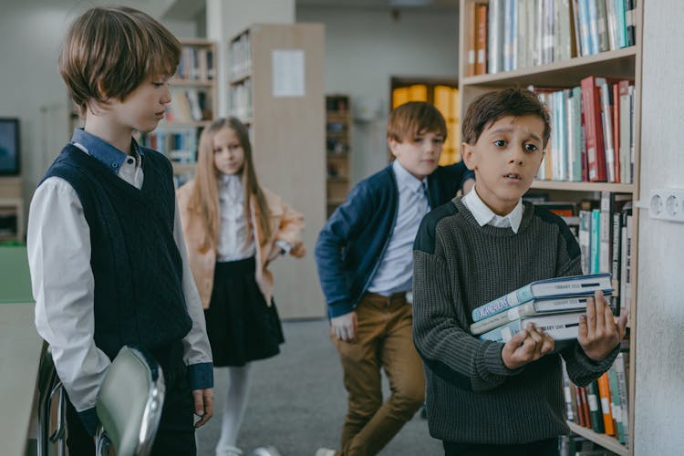 Boy In Black Long Sleeve Shirt Holding Books