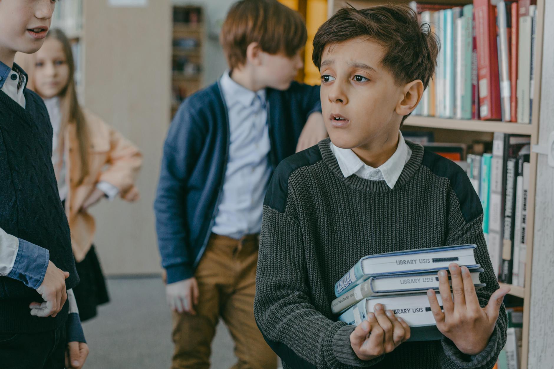 boy-in-black-and-gray-sweater-holding-books- Recognizing Mental Health Issues in Children