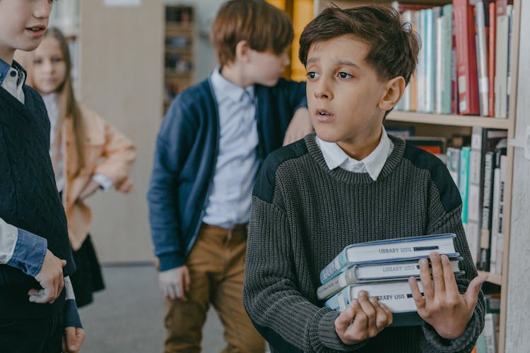 Boy In Black And Gray Sweater Holding Books