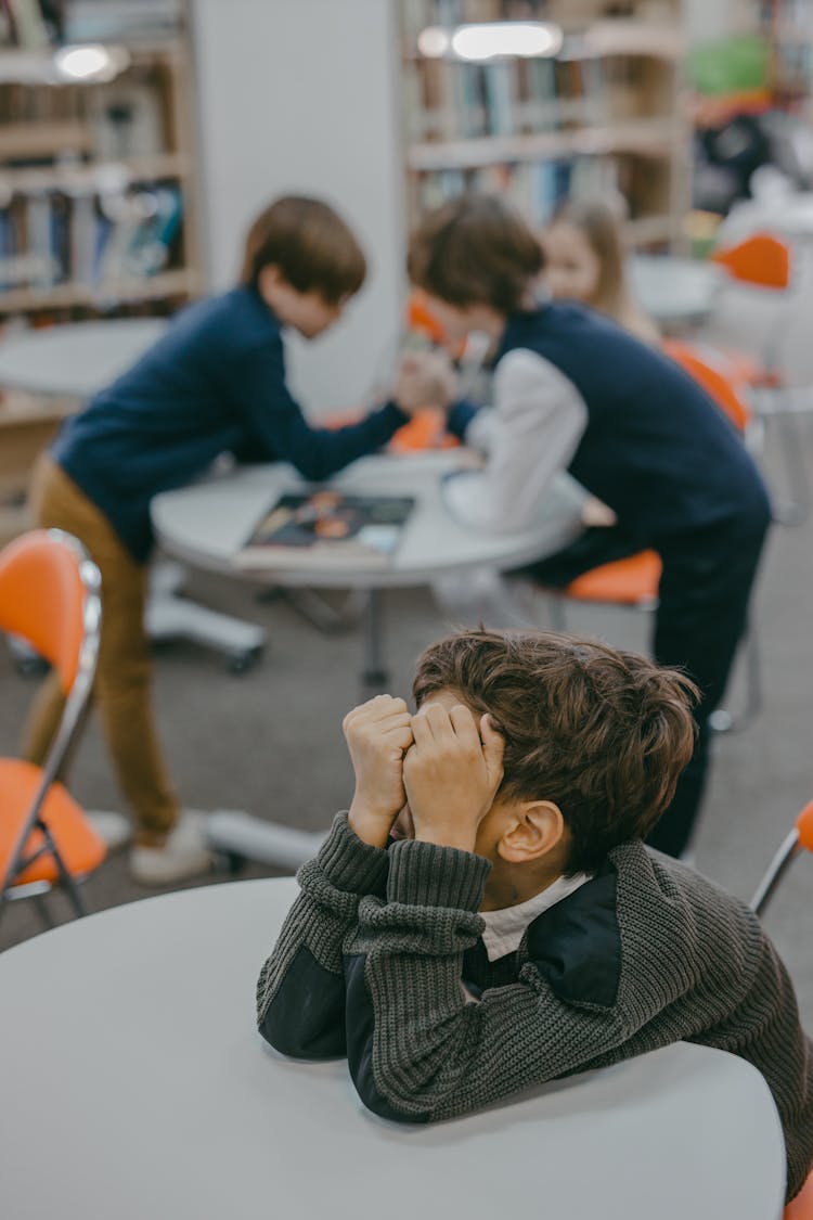 A Boy Sitting Alone In The Library