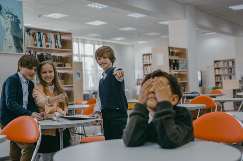 Free Children at school displaying playful bullying in a classroom setting. Stock Photo