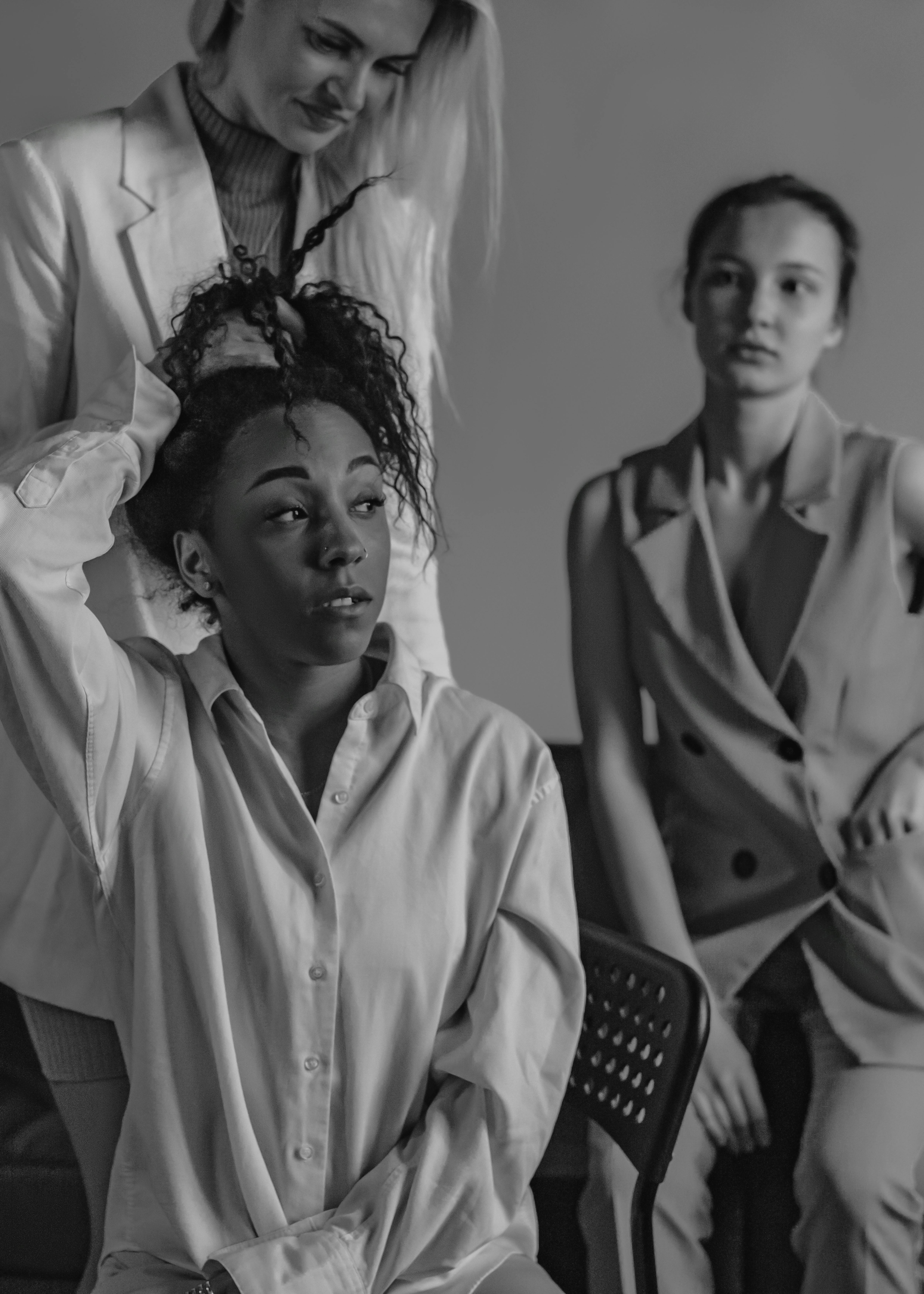 A tense office meeting captured in black and white, highlighting diversity and emotions.