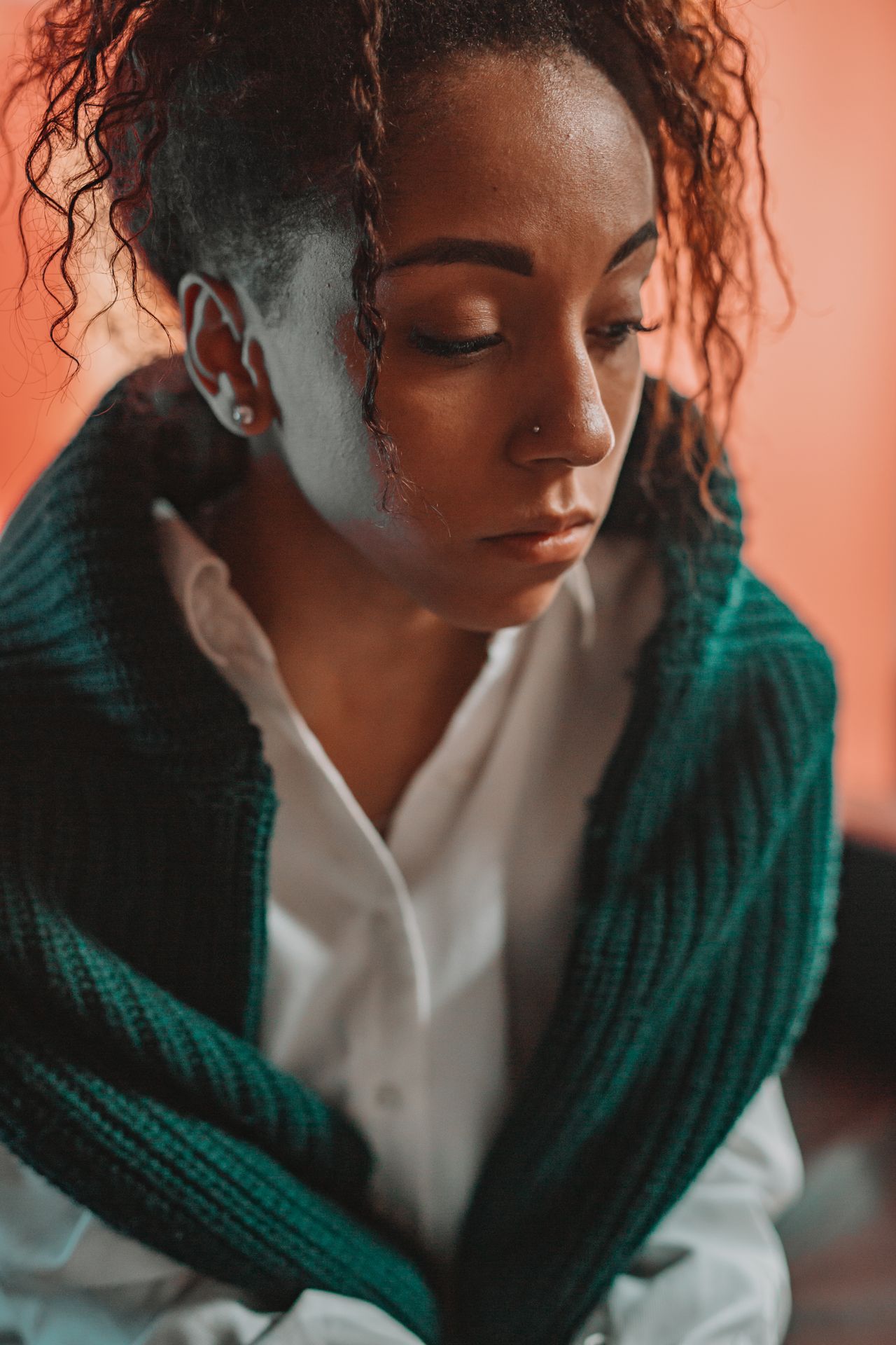 Woman in a green knit cardigan over a white shirt