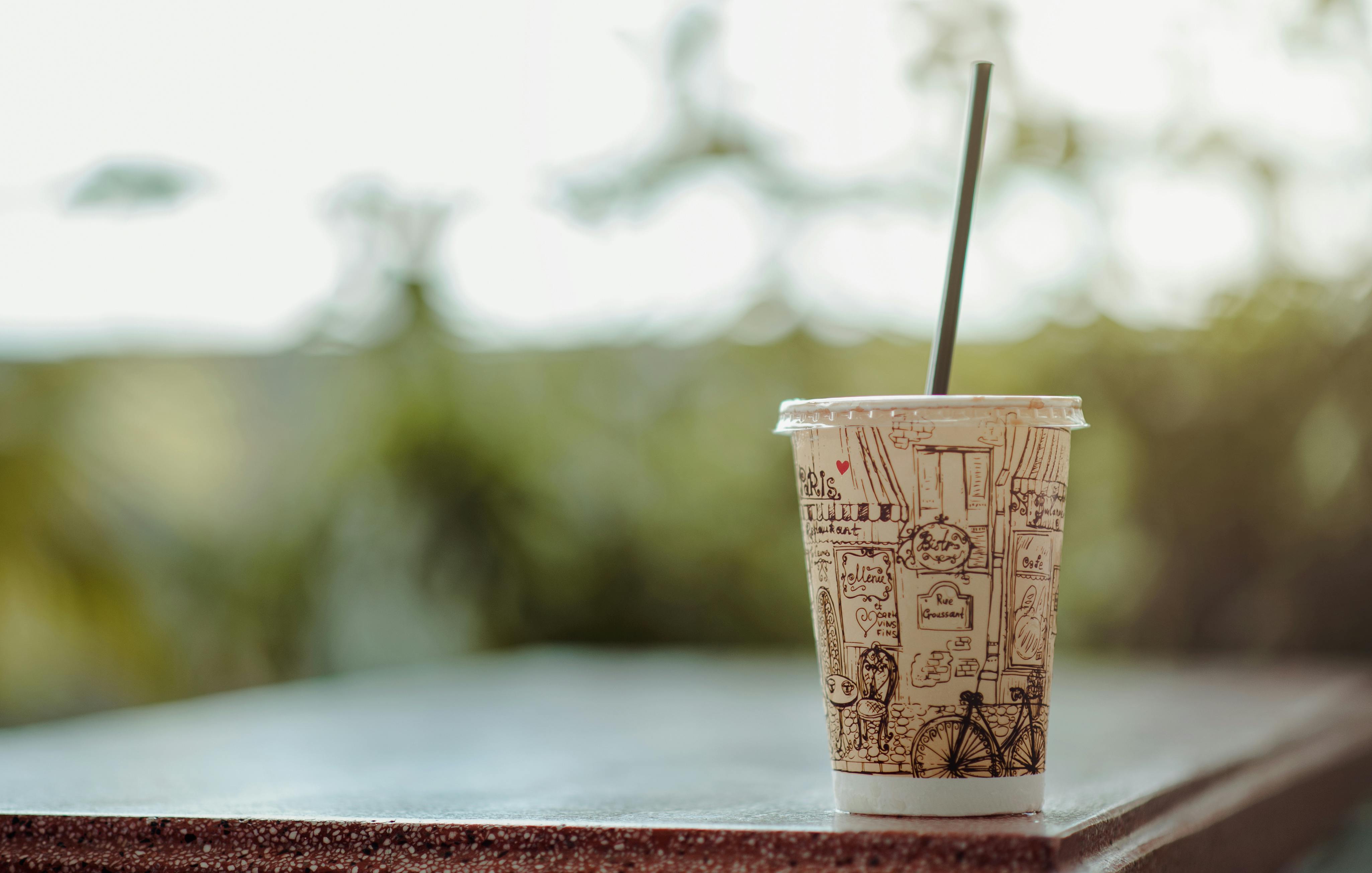 white plastic cups with lids and straws