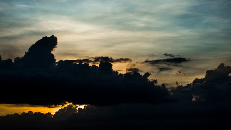 Storm cloud breaking up over a low sun — photo by Nothing Ahead on Pexels