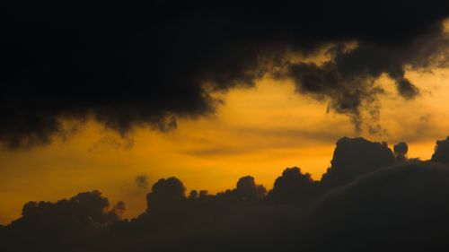 Free Striking skyscape with dramatic orange hues and dark clouds at sunset, perfect for atmospheric visuals. Stock Photo