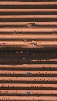 Detailed view of a rusted, weathered corrugated steel surface showing texture and pattern.