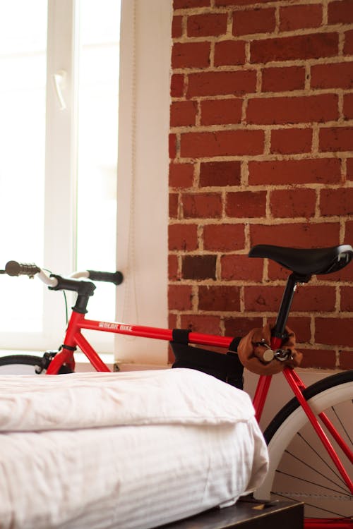 Red and Black Bicycle Near White Textile