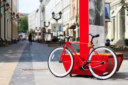 Free A Red and Black Bicycle Parked Against a Signage in the Street Stock Photo