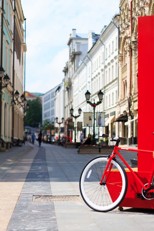 Free A Bicycle Parked Near a Red Wall on the Street Stock Photo