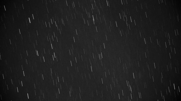 Black and white photo of star trails created with long exposure at night.