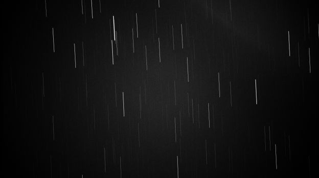 Abstract black and white scene with streaks of light in long exposure, depicting motion and dynamic lines.