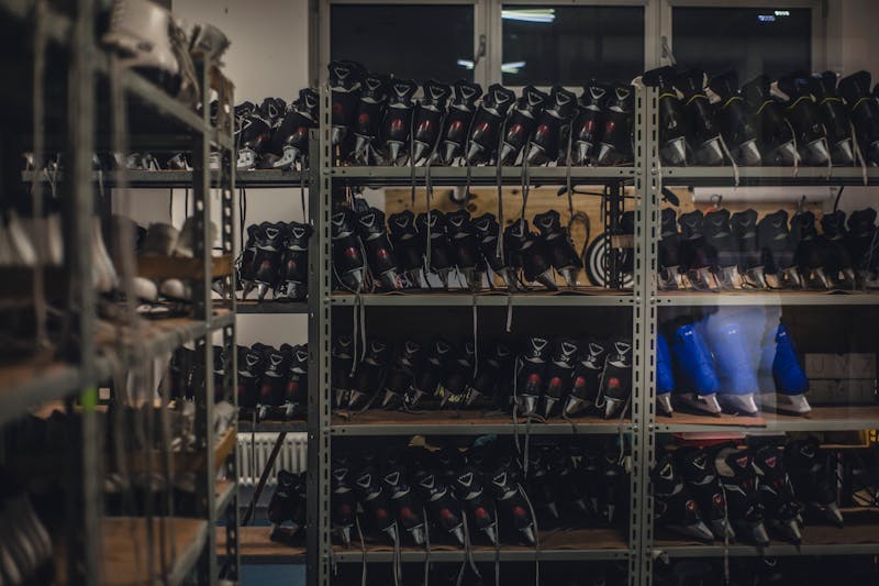 Neatly organized skate boots on shelves in an indoor shop setting, ready for sale.