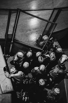 Aerial black and white shot of an ice hockey team preparing at the rink entrance.