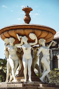 Classic stone sculptures form an artistic fountain centerpiece outdoors.