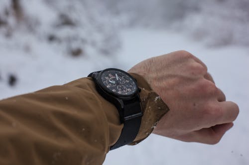 Person in Brown Long-sleeved Top Wearing Chronograph Watch