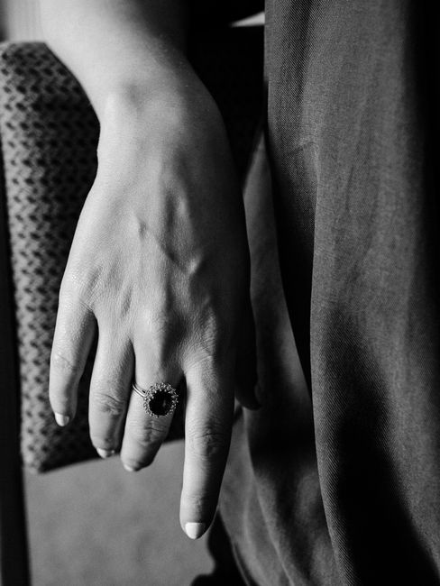 Black and white photo of a hand wearing a sapphire ring, showcasing elegance and sophistication.