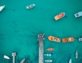 在巴西维拉诺瓦，航拍照片中充满活力的船只停靠在木码头旁的碧绿海水中