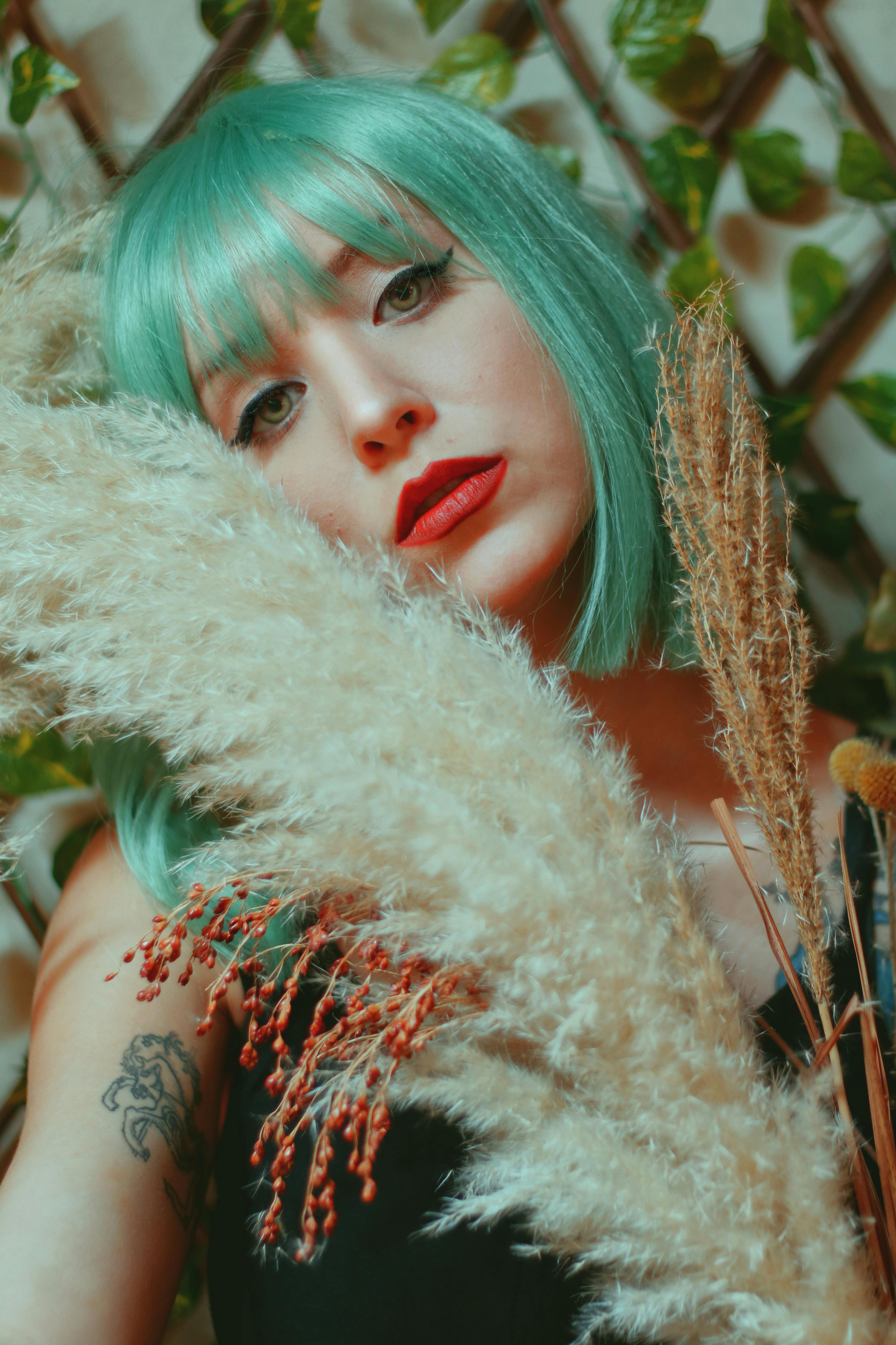 Artistic portrait of a woman with green hair and pampas grass in Lisbon.