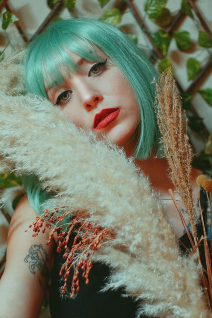 Artistic portrait of a woman with green hair and pampas grass in Lisbon.