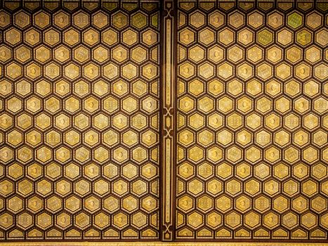 Elegant golden hexagonal pattern decorates the ceiling with intricate geometrical design.