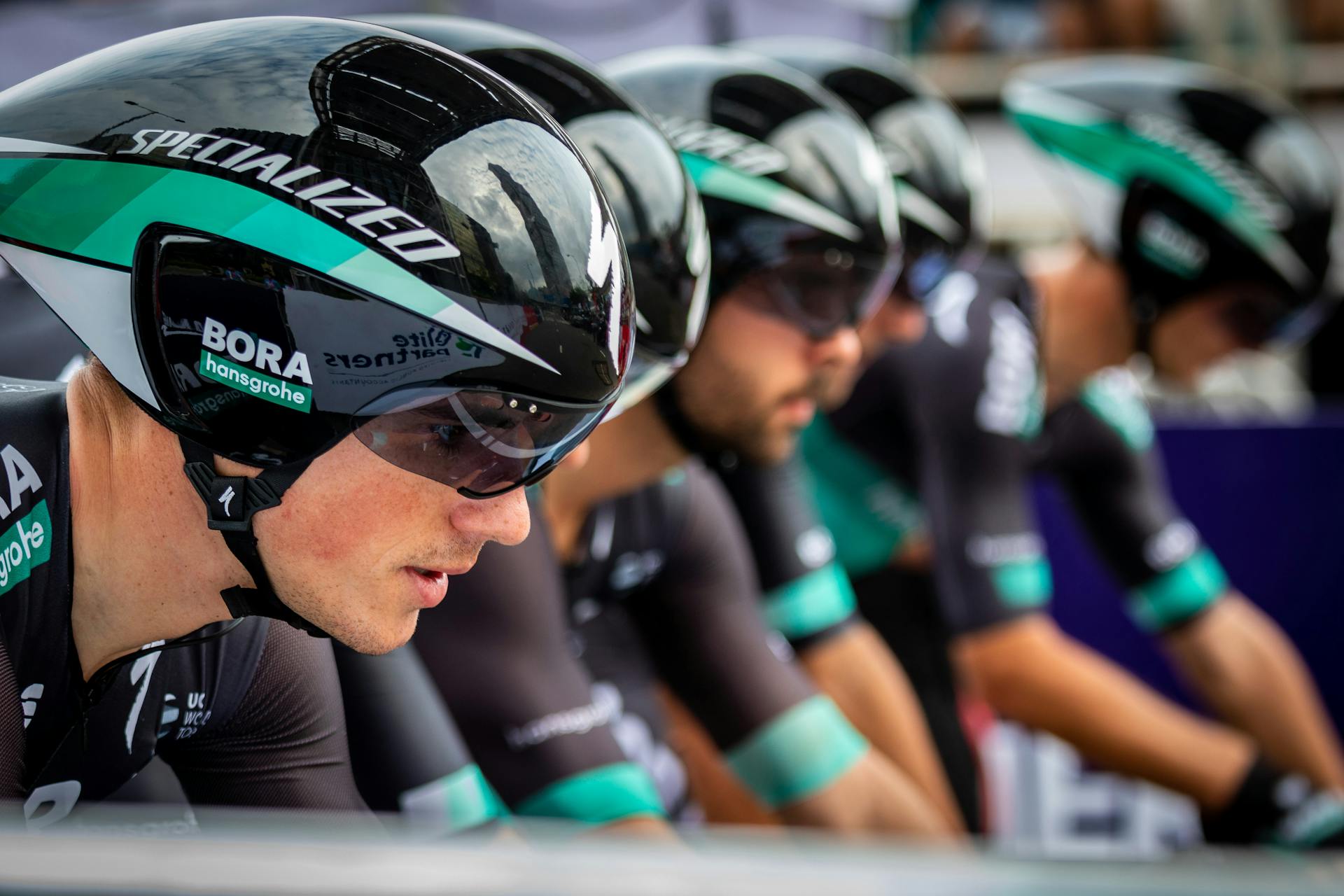 Close-up of professional cyclists in a competitive race wearing aerodynamic helmets in Hong Kong.